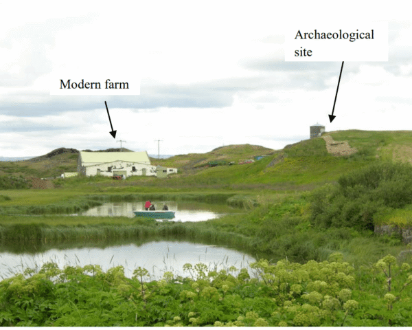 Photo of Icelandic countryside, featuring a farm, an archaeological site, and two lakes with some people in a boat.